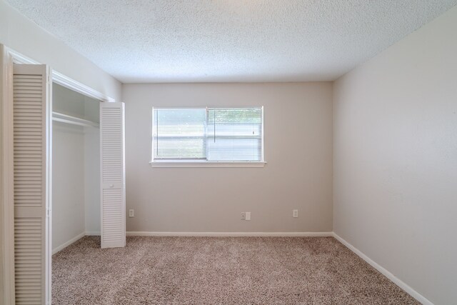 463 Dover Ln, Spring, TX 77373 - unfurnished bedroom featuring carpet, a closet, and a textured ceiling