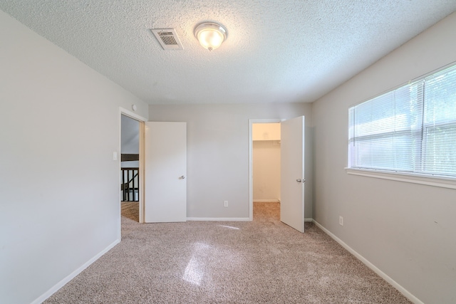 463 Dover Ln, Spring, TX 77373 - unfurnished bedroom with carpet floors, a textured ceiling, and a walk in closet
