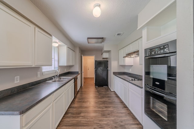 463 Dover Ln, Spring, TX 77373 - kitchen with black appliances, dark countertops, under cabinet range hood, dark wood-style flooring, and a textured ceiling