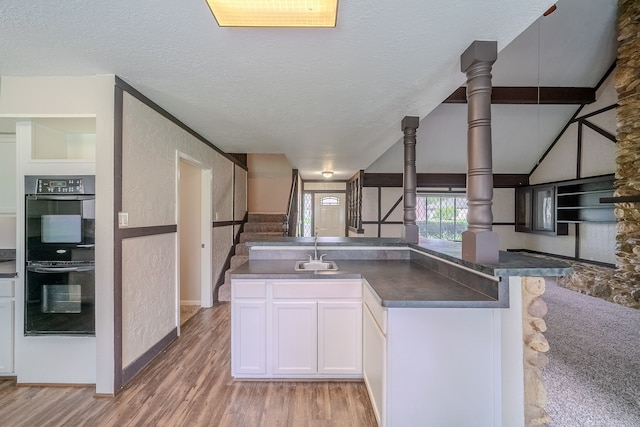 463 Dover Ln, Spring, TX 77373 - kitchen featuring dark countertops, light wood finished floors, white cabinetry, a textured ceiling, and open floor plan