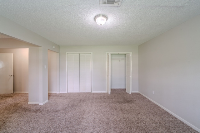 463 Dover Ln, Spring, TX 77373 - unfurnished bedroom featuring multiple closets, carpet floors, and a textured ceiling