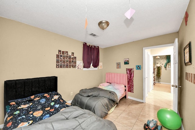 4827 Dalmatian Dr, Houston, TX 77045 - bedroom with light tile patterned floors and a textured ceiling