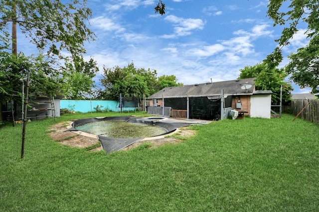 4827 Dalmatian Dr, Houston, TX 77045 - fenced backyard featuring a trampoline, a sunroom, and a patio