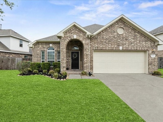13215 Dover Bluff Dr, Rosharon, TX 77583 - view of front of house with brick siding, an attached garage, driveway, and roof with shingles