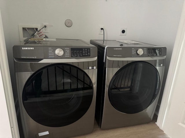 2213 Lee St, Houston, TX 77026 - laundry room featuring washing machine and clothes dryer and wood finished floors