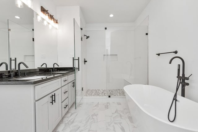 2213 Lee St, Houston, TX 77026 - bathroom with a freestanding bath, double vanity, marble look tiles, a stall shower, and recessed lighting