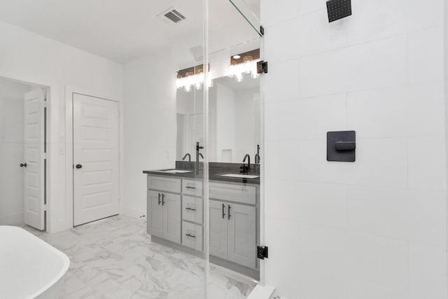 2213 Lee St, Houston, TX 77026 - bathroom with double vanity, marble look tile flooring, and a freestanding bath