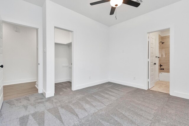 2213 Lee St, Houston, TX 77026 - unfurnished bedroom featuring carpet floors, a walk in closet, ensuite bathroom, and a ceiling fan