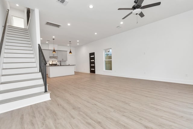 2213 Lee St, Houston, TX 77026 - unfurnished living room featuring a ceiling fan, light wood-type flooring, recessed lighting, and stairs