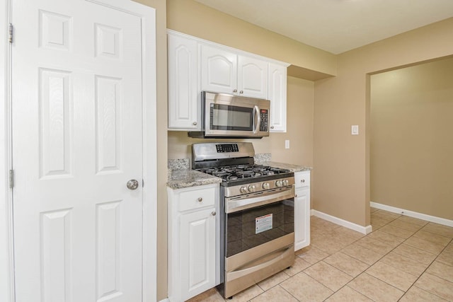 1011 Minnesota St, South Houston, TX 77587 - kitchen featuring stainless steel appliances, white cabinets, light stone counters, and light tile patterned floors
