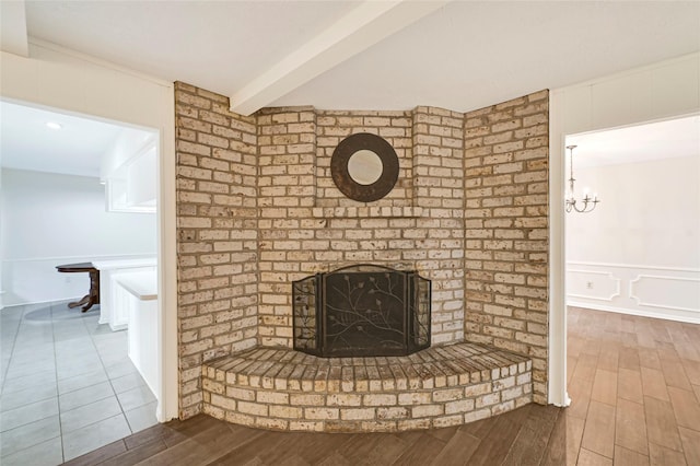 9306 Claridge Dr, Houston, TX 77031 - unfurnished living room featuring wood finished floors, a fireplace, beamed ceiling, and a chandelier