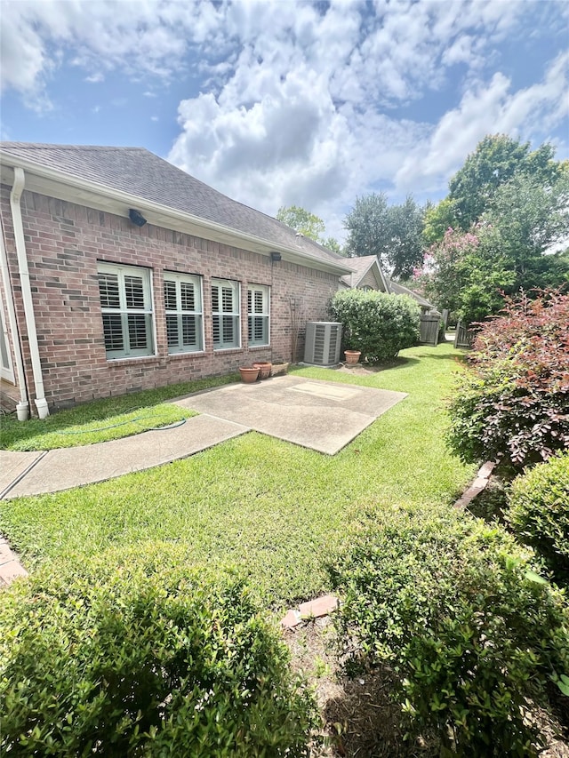 1150 Sienna Hill Dr, Houston, TX 77077 - rear view of house with a patio area, brick siding, a lawn, and roof with shingles