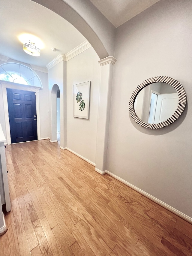 1150 Sienna Hill Dr, Houston, TX 77077 - entrance foyer with arched walkways, crown molding, light wood-style floors, and decorative columns