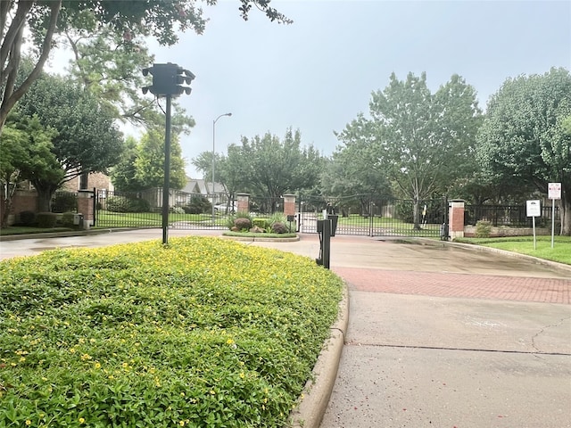 1150 Sienna Hill Dr, Houston, TX 77077 - view of road with a gate, curbs, street lights, and a gated entry