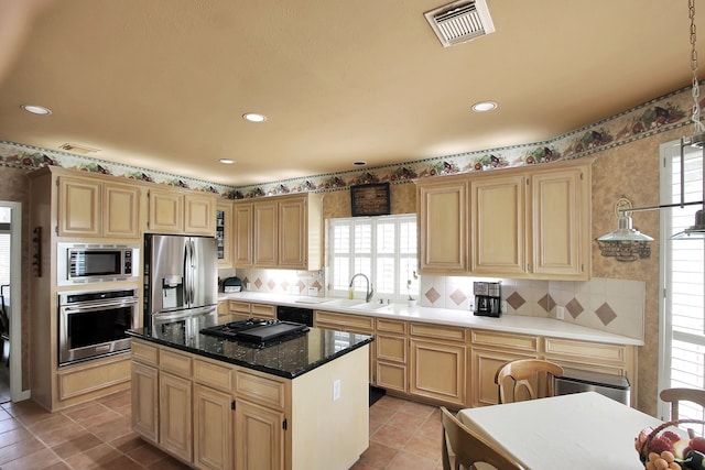603 Forest Bend Ln, Friendswood, TX 77546 - kitchen with appliances with stainless steel finishes, tasteful backsplash, a kitchen island, light brown cabinetry, and recessed lighting