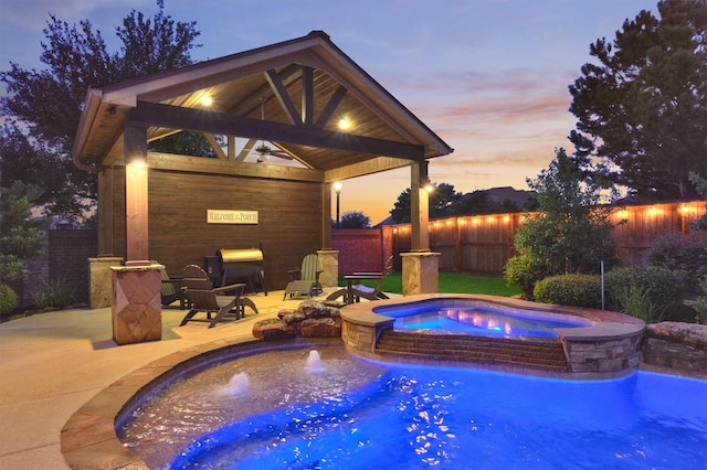 9714 Luna Springs Ln, Cypress, TX 77433 - pool at dusk with a gazebo, a pool with connected hot tub, a fenced backyard, and a patio area