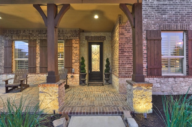 9714 Luna Springs Ln, Cypress, TX 77433 - view of exterior entry featuring a porch, brick siding, and stone siding