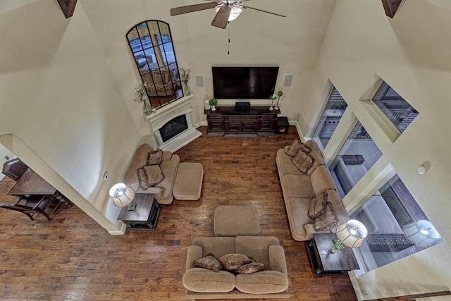 9714 Luna Springs Ln, Cypress, TX 77433 - living room with a towering ceiling, wood finished floors, ceiling fan, and a fireplace