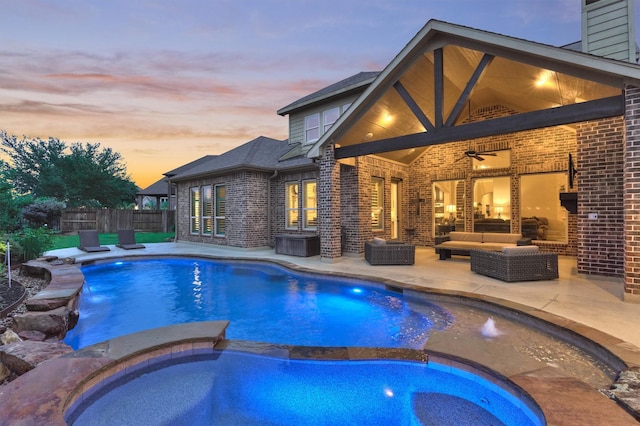 9714 Luna Springs Ln, Cypress, TX 77433 - pool at dusk with an outdoor hangout area, a patio, a pool with connected hot tub, and a ceiling fan