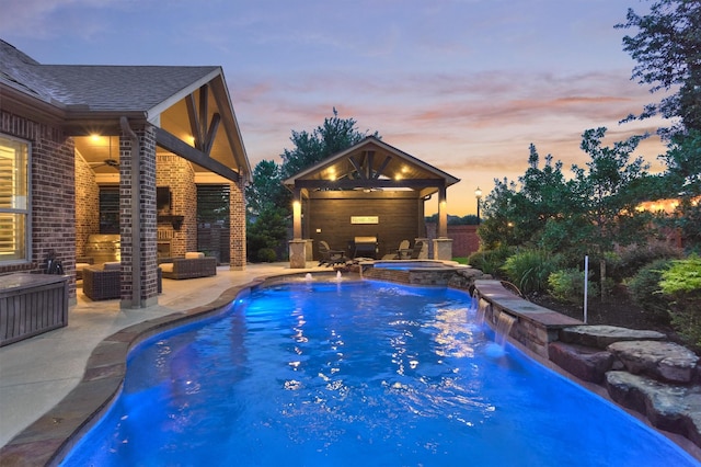 9714 Luna Springs Ln, Cypress, TX 77433 - pool at dusk featuring outdoor lounge area, a patio, a ceiling fan, and a pool with connected hot tub