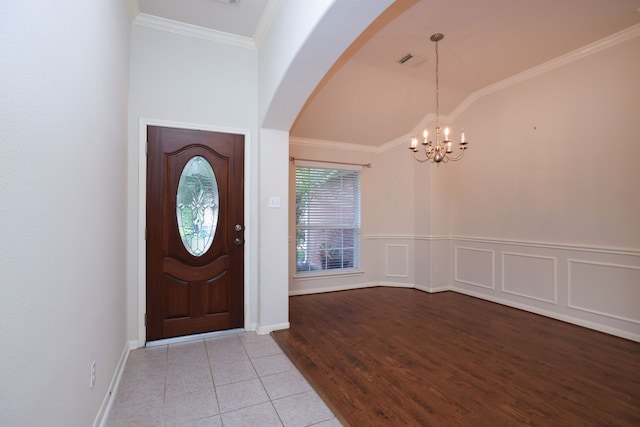 30515 Red Bluff Cir, Magnolia, TX 77355 - entrance foyer featuring arched walkways, a chandelier, vaulted ceiling, tile patterned flooring, and crown molding