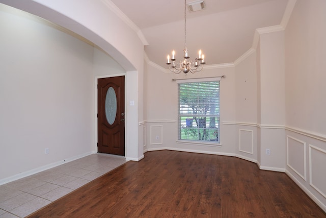 30515 Red Bluff Cir, Magnolia, TX 77355 - foyer with a chandelier, wood finished floors, crown molding, wainscoting, and arched walkways