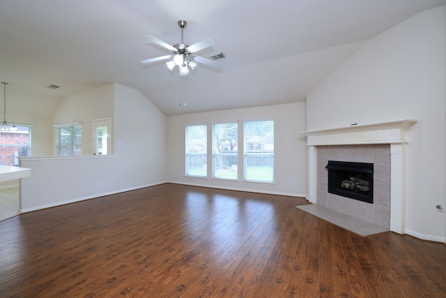 30515 Red Bluff Cir, Magnolia, TX 77355 - unfurnished living room featuring vaulted ceiling, dark wood-style flooring, a tiled fireplace, and ceiling fan