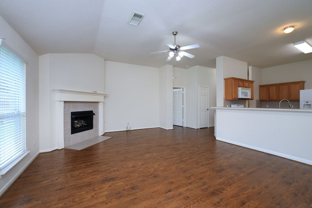 30515 Red Bluff Cir, Magnolia, TX 77355 - unfurnished living room with ceiling fan, dark wood-style flooring, a tile fireplace, and vaulted ceiling