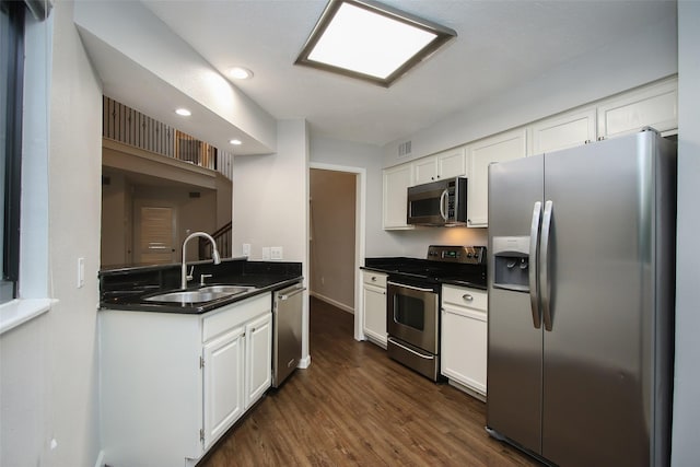 9400 Doliver Dr Unit 70, Houston, TX 77063 - kitchen with stainless steel appliances, dark countertops, dark wood finished floors, white cabinets, and recessed lighting