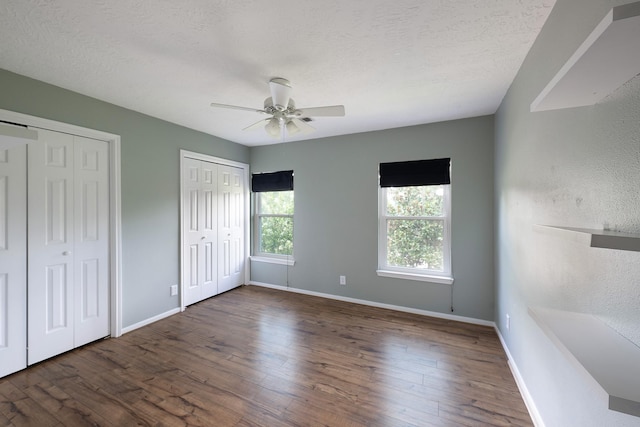 15434 Redbud Leaf Ln, Cypress, TX 77433 - unfurnished bedroom with two closets, hardwood / wood-style flooring, a textured ceiling, a ceiling fan, and a textured wall