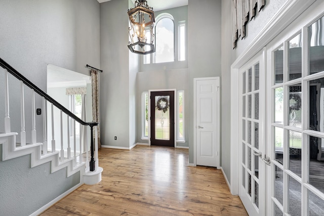 15434 Redbud Leaf Ln, Cypress, TX 77433 - foyer entrance featuring a high ceiling, a chandelier, french doors, stairway, and wood finished floors