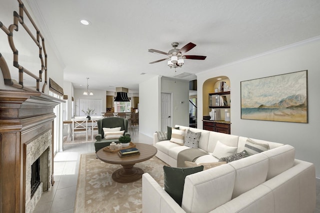 15434 Redbud Leaf Ln, Cypress, TX 77433 - living room with a fireplace, crown molding, a ceiling fan, light tile patterned floors, and stairway