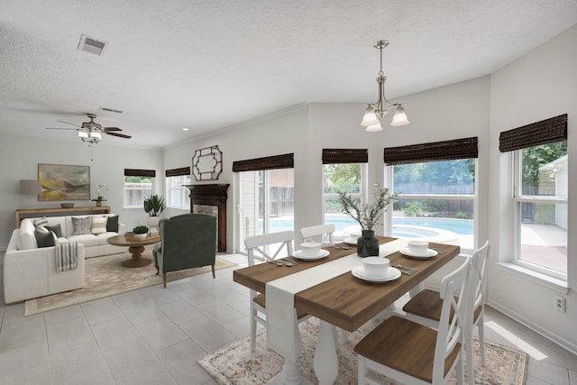 15434 Redbud Leaf Ln, Cypress, TX 77433 - dining space with a textured ceiling, ceiling fan, a chandelier, and light tile patterned flooring