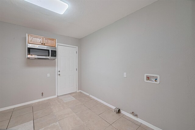 3024 Brackenridge St, Houston, TX 77026 - washroom with gas dryer hookup, hookup for a washing machine, light tile patterned floors, and a textured ceiling
