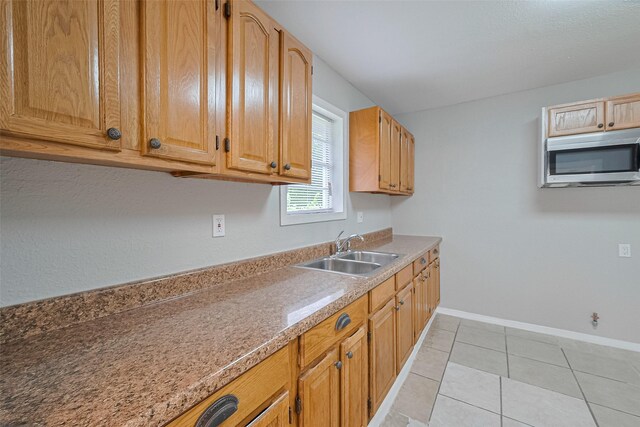 3024 Brackenridge St, Houston, TX 77026 - kitchen with stainless steel microwave, light countertops, and light tile patterned floors