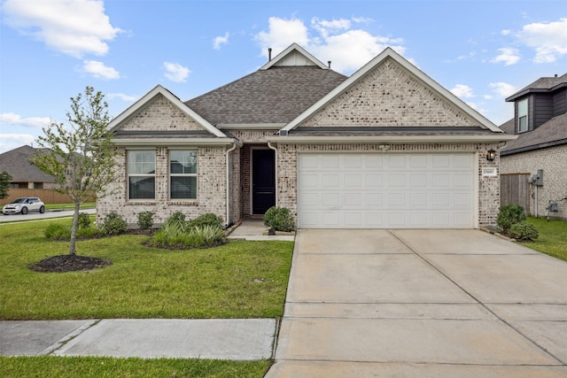 15603 Beltie Dr, Humble, TX 77346 - view of front of house with a front lawn, a garage, driveway, brick siding, and a shingled roof