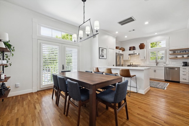5220 Hazard St, Houston, TX 77098 - dining space with light wood-type flooring, ornamental molding, and recessed lighting