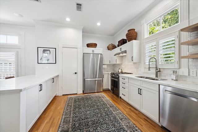 5220 Hazard St, Houston, TX 77098 - kitchen with appliances with stainless steel finishes, open shelves, a peninsula, plenty of natural light, and crown molding
