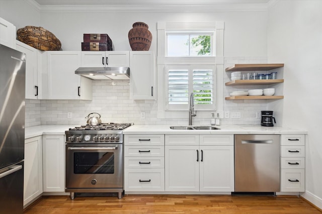 5220 Hazard St, Houston, TX 77098 - kitchen featuring appliances with stainless steel finishes, under cabinet range hood, ornamental molding, decorative backsplash, and white cabinetry