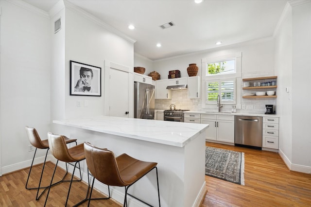 5220 Hazard St, Houston, TX 77098 - kitchen with high quality appliances, crown molding, decorative backsplash, a breakfast bar area, and light stone counters