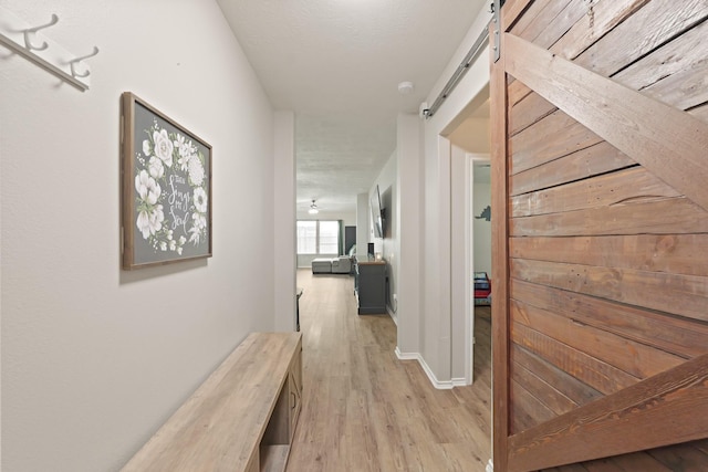 15010 Sunset Villa Ct, Humble, TX 77396 - hallway featuring a barn door and light wood finished floors