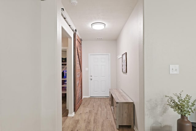 15010 Sunset Villa Ct, Humble, TX 77396 - corridor with a barn door and light wood finished floors