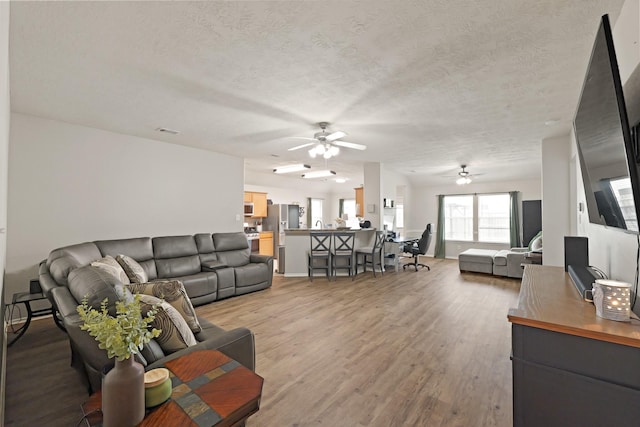 15010 Sunset Villa Ct, Humble, TX 77396 - living area with ceiling fan, light wood-style floors, and a textured ceiling