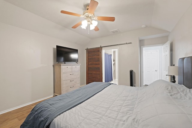 15010 Sunset Villa Ct, Humble, TX 77396 - bedroom featuring vaulted ceiling, a barn door, wood finished floors, and ceiling fan