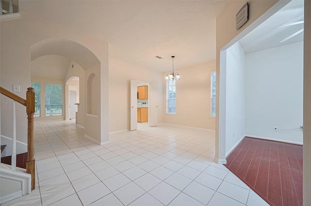 17134 Fairway Glen Ct, Sugar Land, TX 77498 - spare room featuring healthy amount of natural light, stairs, light tile patterned flooring, and a chandelier