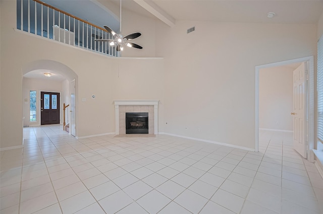 17134 Fairway Glen Ct, Sugar Land, TX 77498 - unfurnished living room with arched walkways, light tile patterned flooring, a ceiling fan, beamed ceiling, and high vaulted ceiling