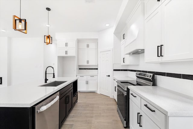 213 N 7th St, La Porte, TX 77571 - kitchen featuring appliances with stainless steel finishes, tasteful backsplash, white cabinets, light wood-style flooring, and decorative light fixtures