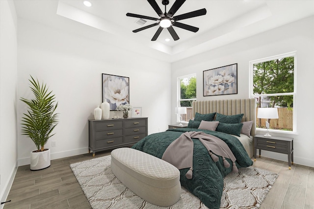 213 N 7th St, La Porte, TX 77571 - bedroom featuring a tray ceiling, multiple windows, light wood-type flooring, recessed lighting, and ceiling fan