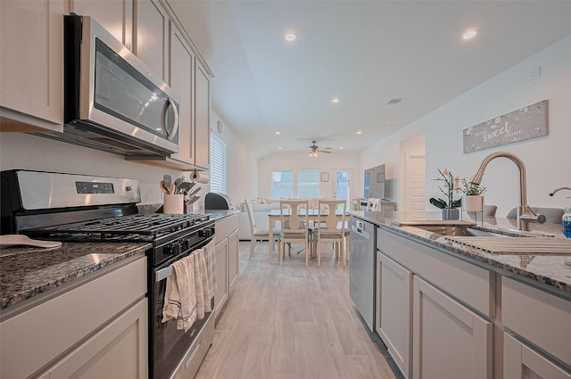 3918 Beltingham Bend Way, Fulshear, TX 77441 - kitchen featuring appliances with stainless steel finishes, a ceiling fan, light wood-type flooring, dark stone counters, and recessed lighting