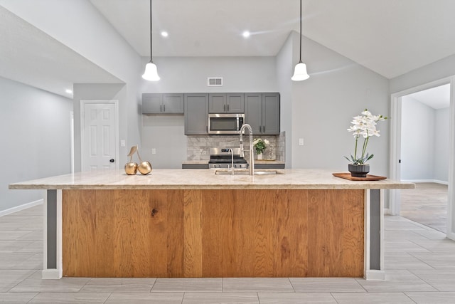 16310 Mulberry Run Ct, Sugar Land, TX 77498 - kitchen featuring stainless steel appliances, gray cabinets, backsplash, a large island, and hanging light fixtures